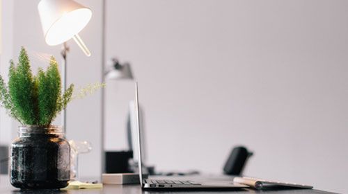 A lamp shining onto a laptop on a desk