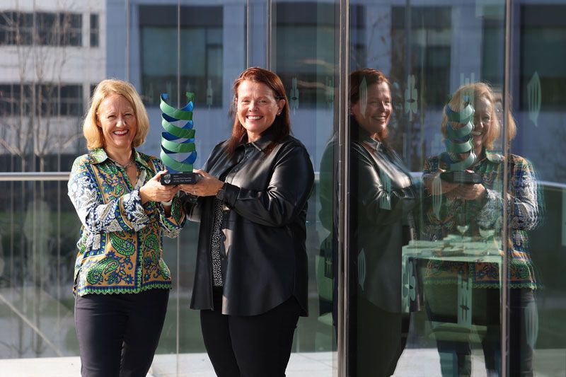 Two womens holding the award with a smile