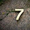 The number 7 on a stone representing 7 facts about Online Exams