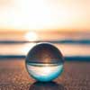 image of a clear sphere ball with the sun setting behind it