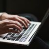 image of hands working on a laptop doing a remotely invigilated exam