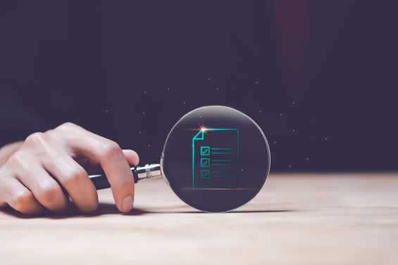 Magnifying glass over a simulated checklist to represent internal audits