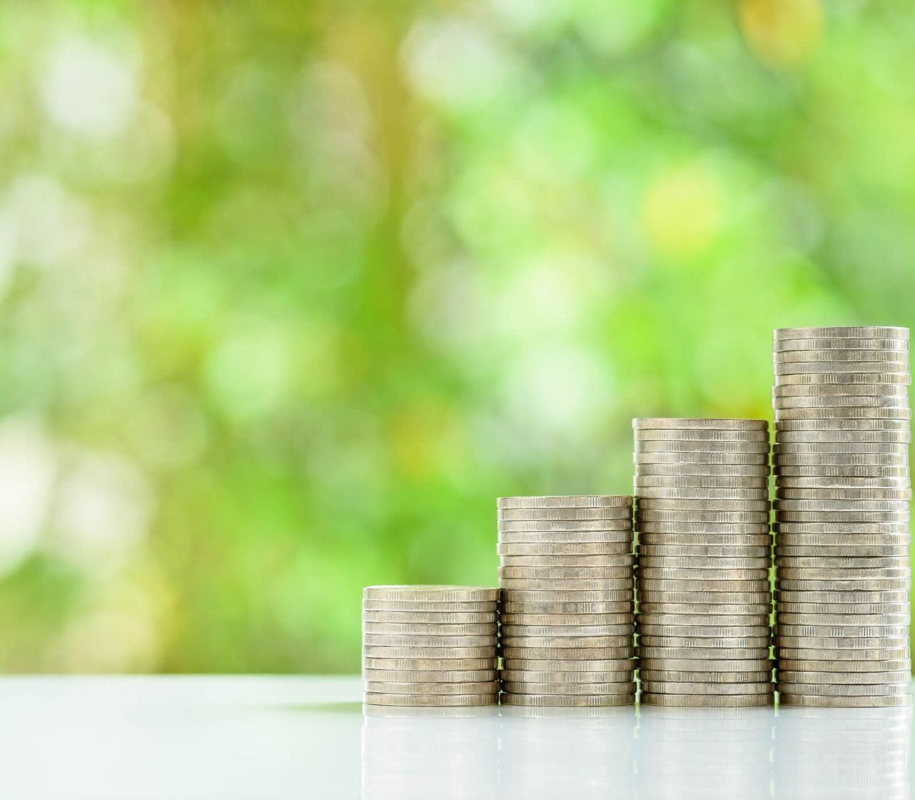 Money stacking up on a table to illustrate the work of the Pensions Management Institute, who use TestReach for online examination delivery.